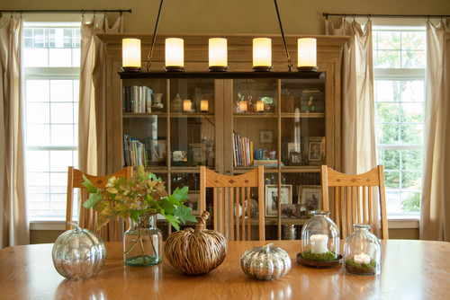 Dining room table centerpieces with candles and pumpkins